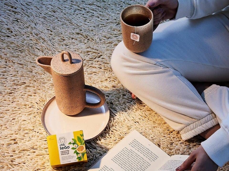 Mulher lendo e tomando chá leão. 